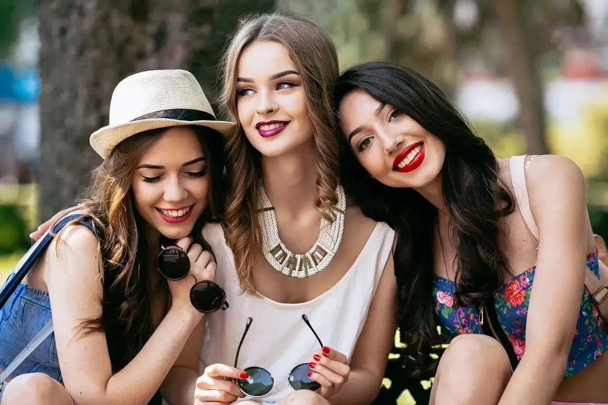 Three women posing for a picture while wearing sunglasses.